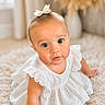 baby, child, girl, white_dress, bow, cute, portrait, indoor, soft_rug, fluffy, curious_eyes, innocence, young_child, candid, closeup, adorable, person, fashion, head_accessory, sitting