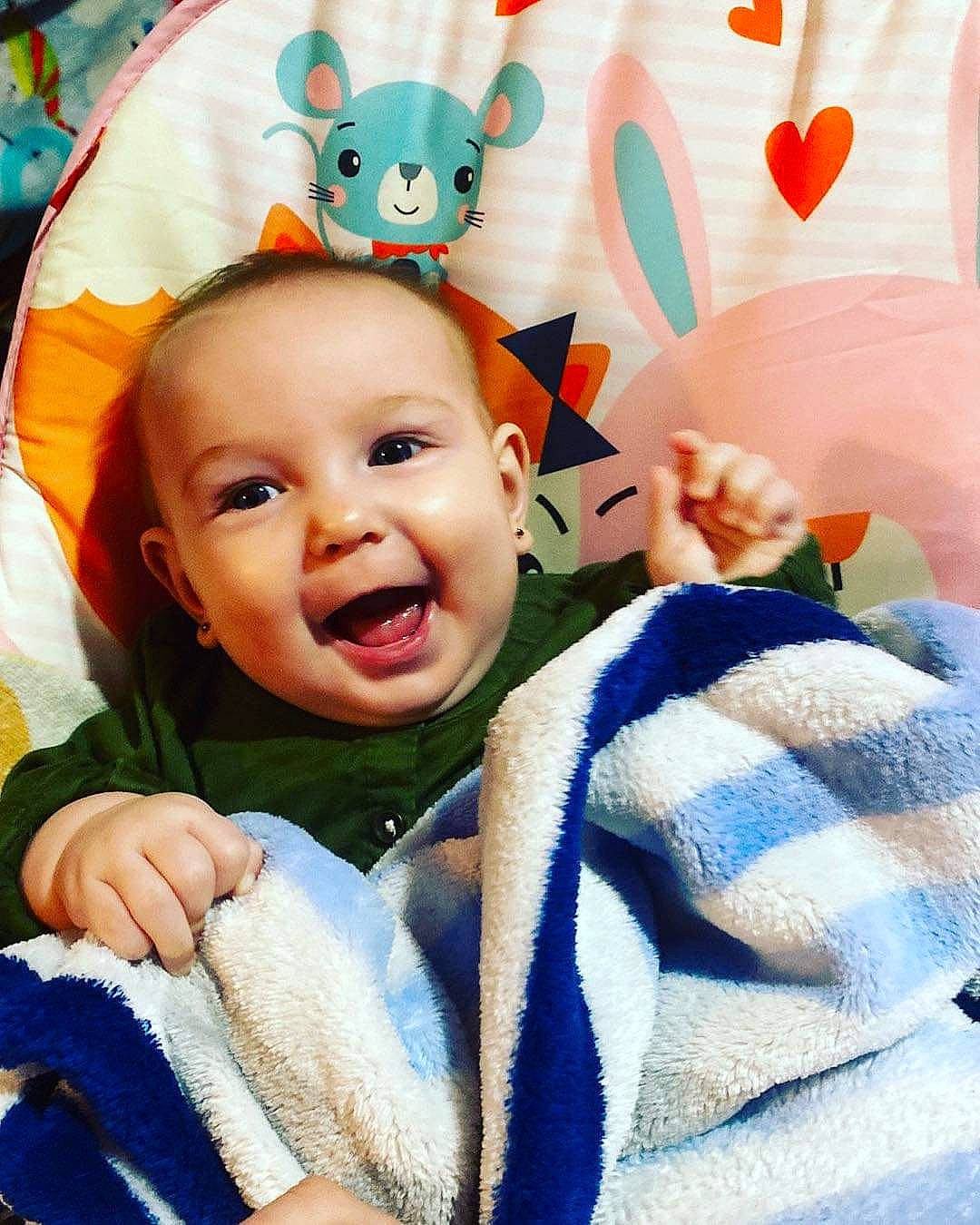 Brynlee is registered to the contest to win money with this photo: baby, baby_products, baby_toddler_clothing, blue, cheek, child, comfort, event, facial_expression, finger, fun, gesture, happy, headgear, linens, person, skin, smile, textile, toddler