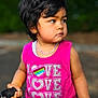 car_key, casual, casual_clothing, child, cute, daylight, fashion, holding_object, jeans, love_text, nature_background, outdoor, person, pink_tank_top, portrait, short_hair, standing, summer, toddler, young_child