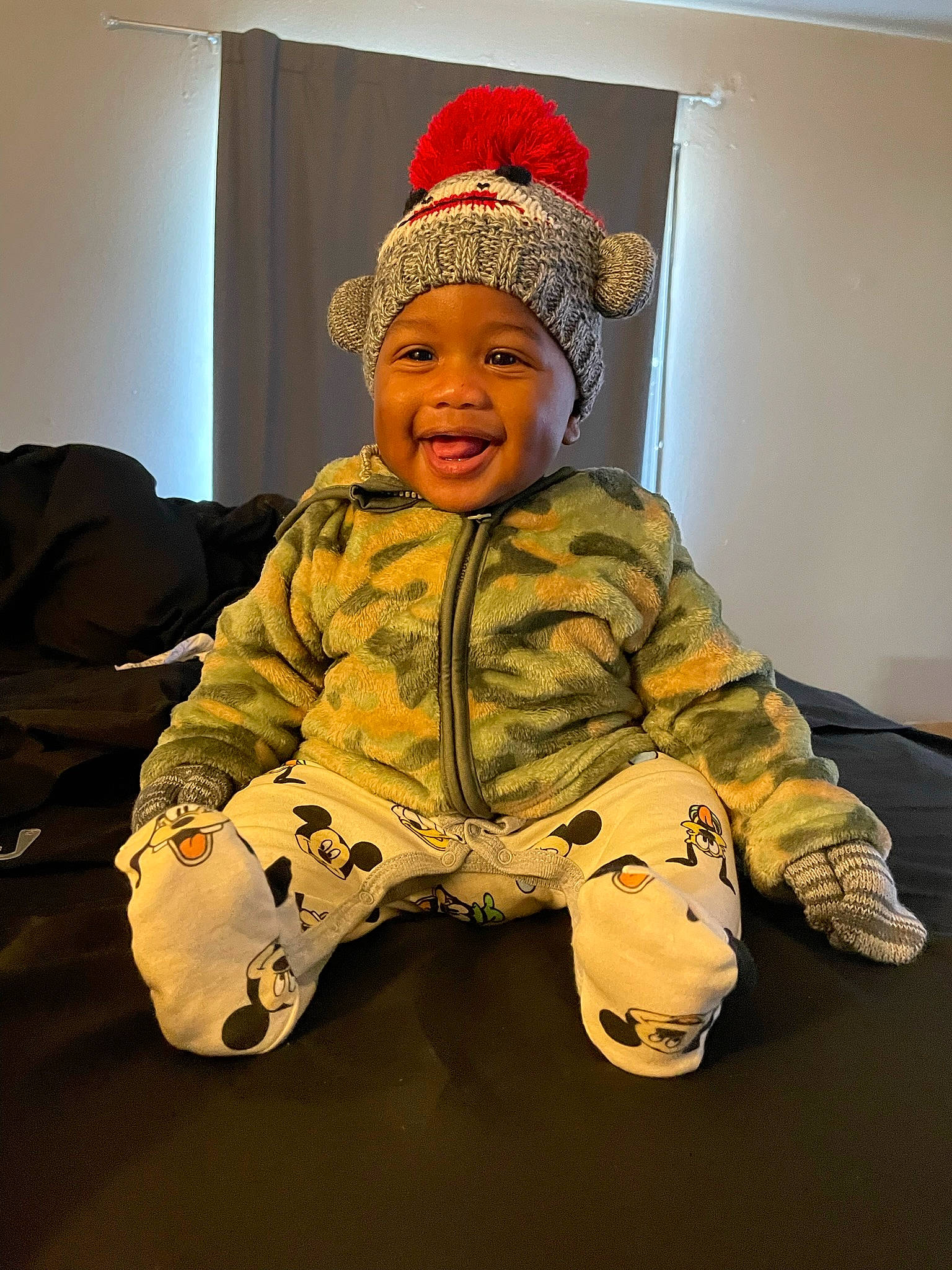 Aylen is registered to the contest to win money with this photo: baby, baby_laughing, baby_toddler_clothing, cap, child, comfort, flooring, fun, fur, happy, headgear, headwear, human_body, jacket, joy, military_camouflage, person, personal_protective_equipment, sitting, sleeve