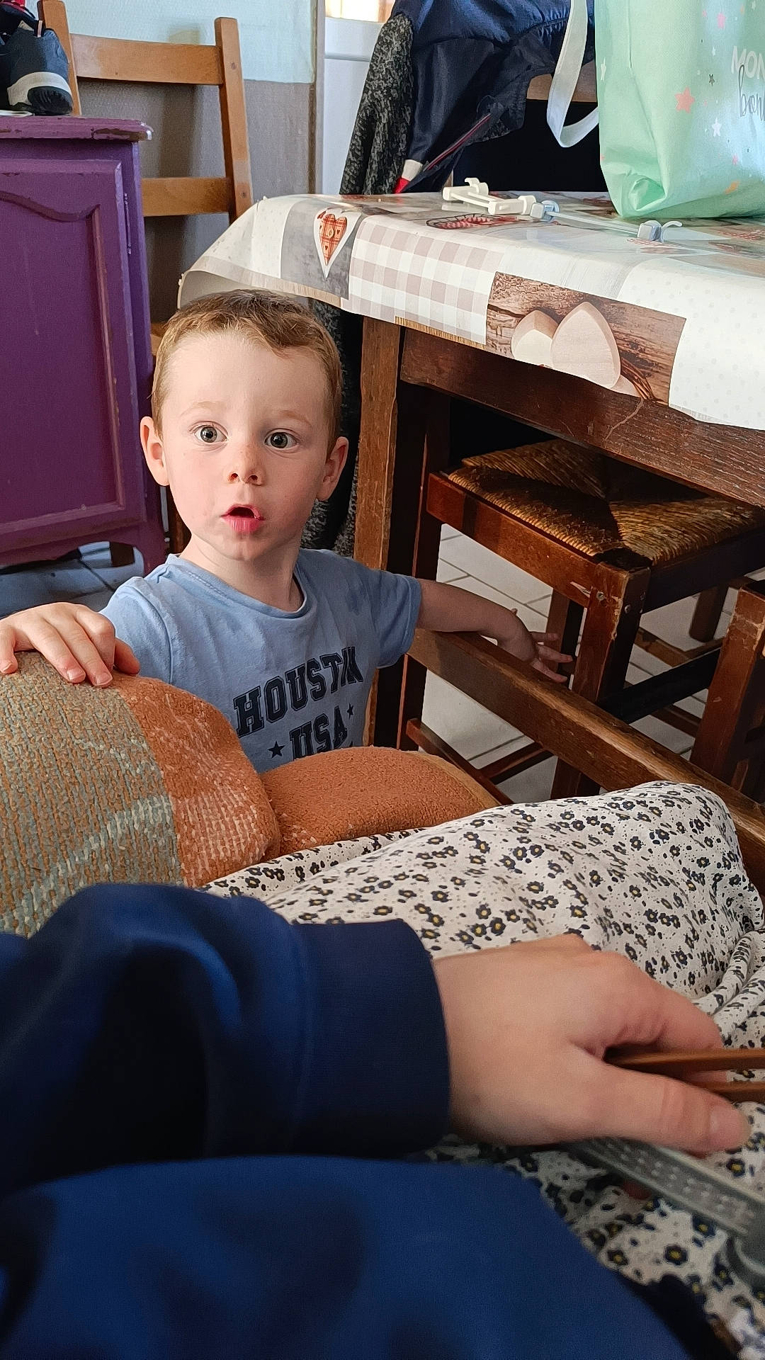 Juliano a rejoint le concours — aidez-le/la à gagner de superbes lots ! chair, child, comfort, flooring, fun, furniture, human_leg, lap, leisure, linens, living_room, pattern, person, room, sitting, sleeve, surprise, t_shirt, table, toddler