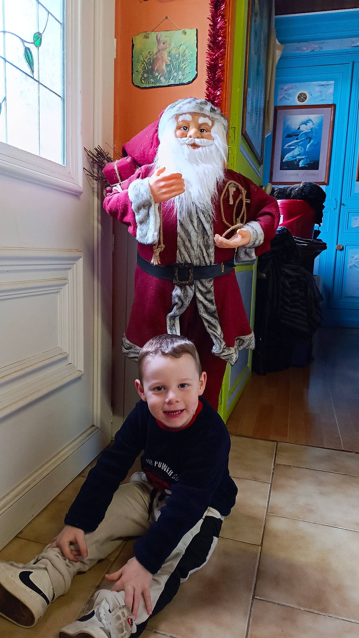 Juliano a rejoint le concours — aidez-le/la à gagner de superbes lots ! beard, blue, door, event, fictional_character, flooring, fun, hat, holiday, joy, lap, people, person, room, santa_claus, shoe, smile, sneakers, toddler, toy