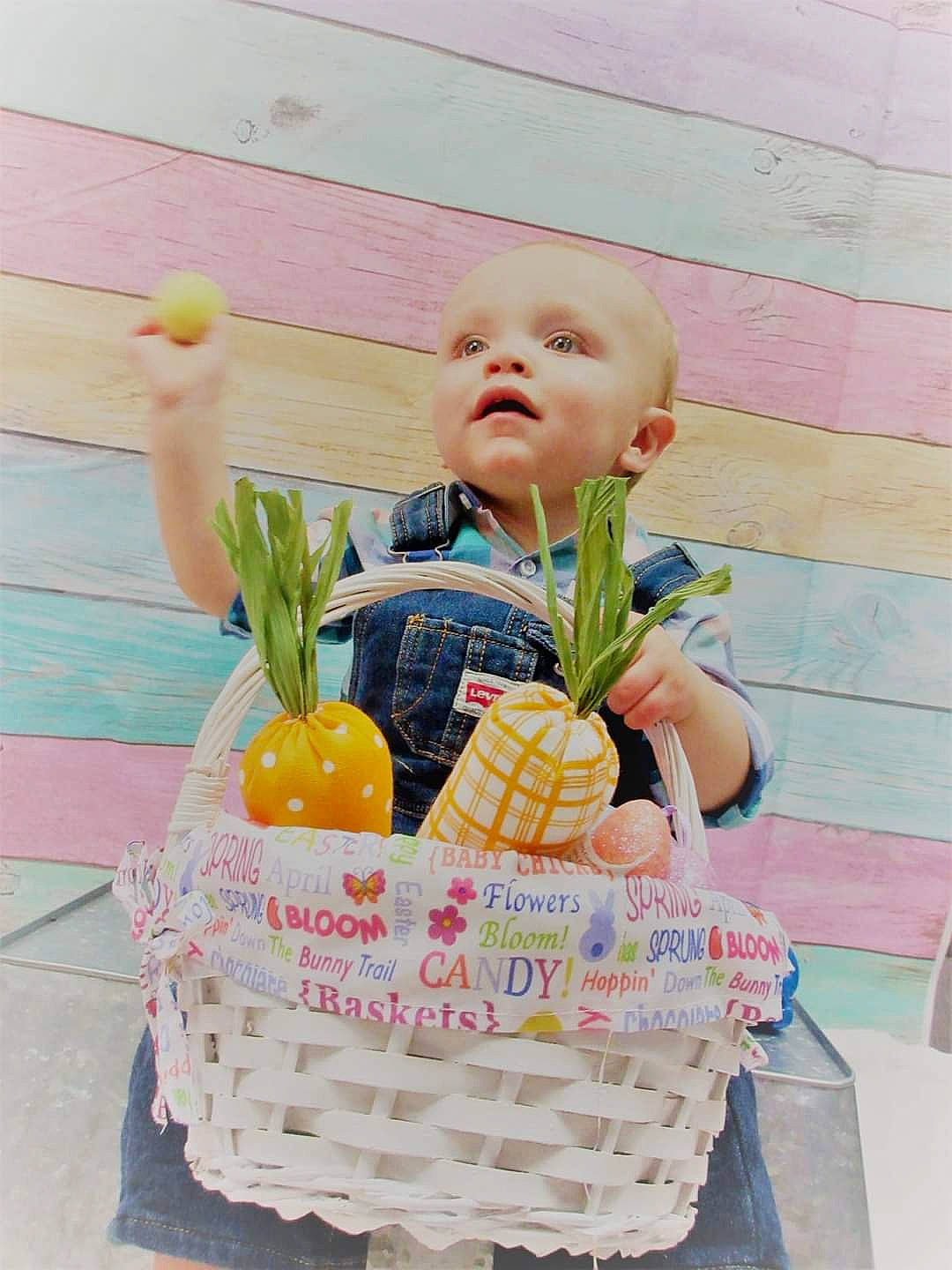 Brandon is registered to the contest to win money with this photo: baby, baby_products, baby_toddler_clothing, basket, child, flooring, fun, grass, happy, natural_foods, orange, pattern, person, picnic_basket, play, product, sitting, storage_basket, sweetness, toddler