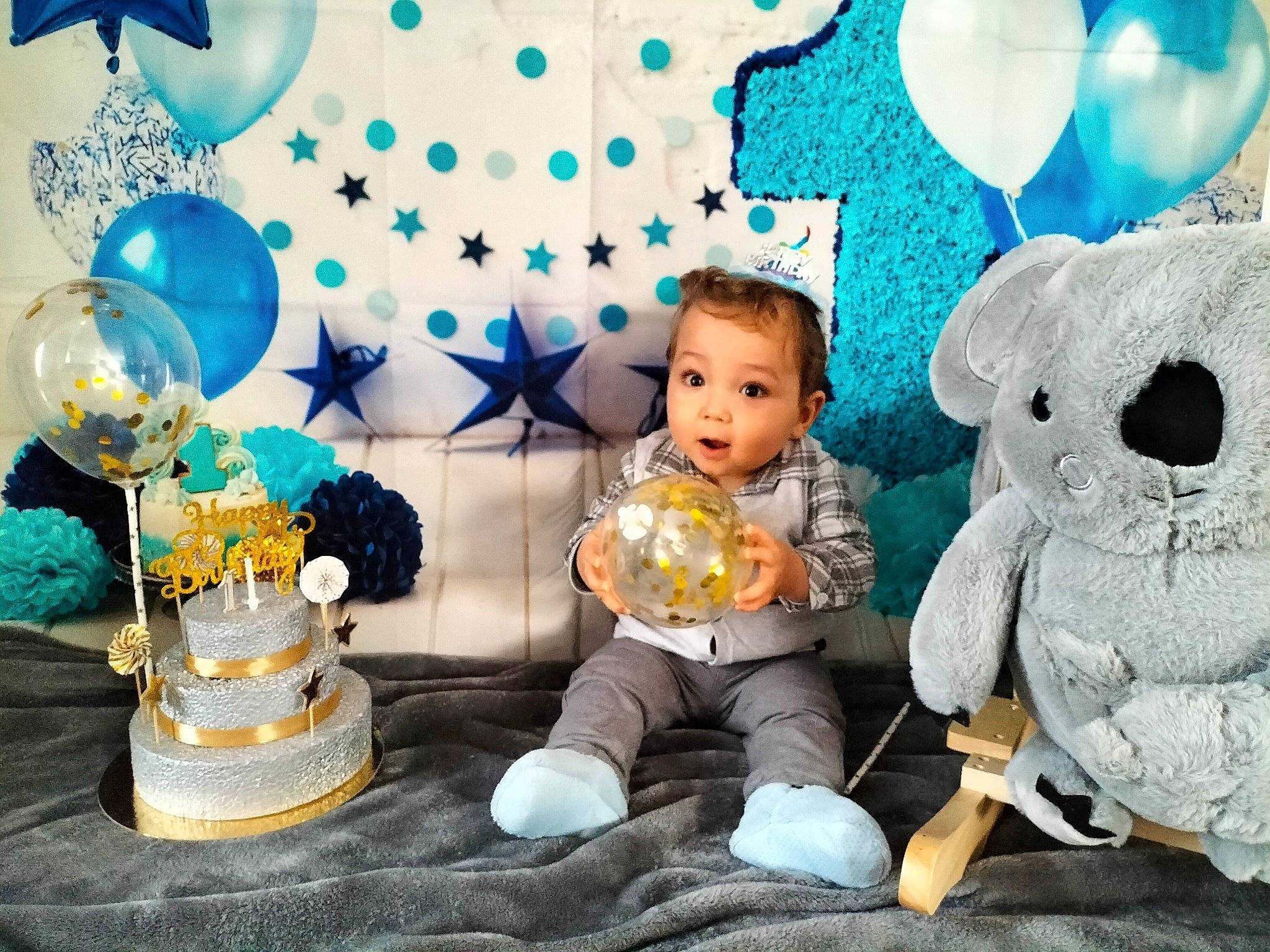 Selyan participe au concours pour gagner de l'argent avec cette photo : baby, baby_toddler_clothing, balloon, birthday_cake, blue, cake, cake_decorating, chair, child, dessert, event, fun, happy, lighting, person, room, sitting, stuffed_toy, sugar_cake, surprise
