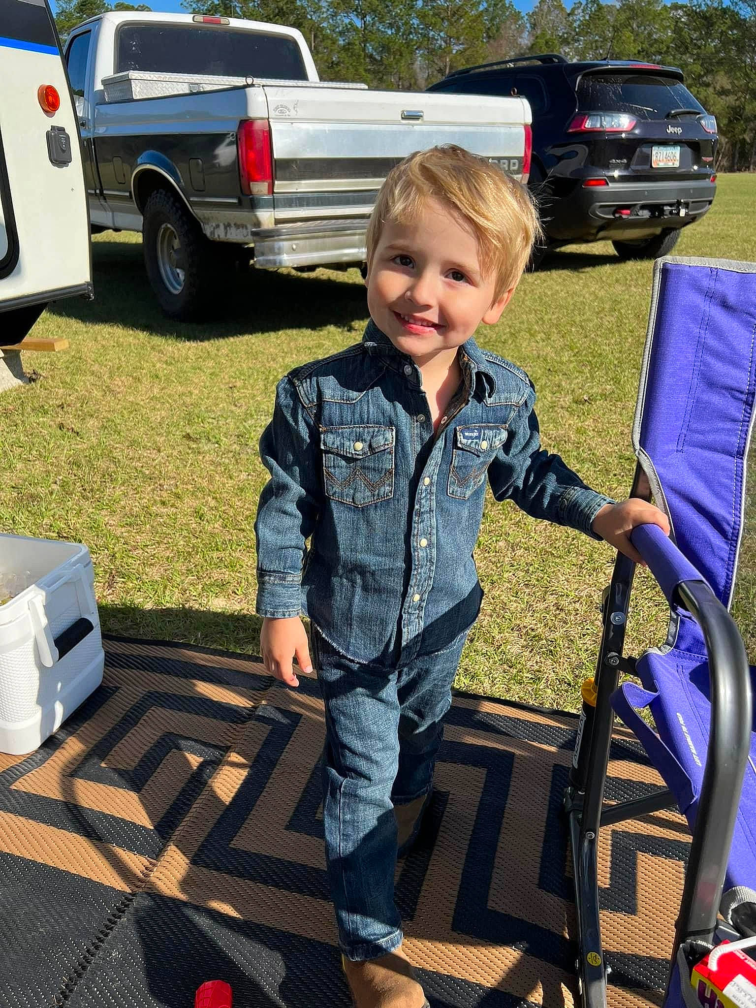 Sawyer is registered to the contest to win money with this photo: automotive_design, automotive_exterior, automotive_lighting, automotive_tail_brake_light, automotive_tire, bumper, car, fender, grass, joy, land_vehicle, motor_vehicle, person, smile, tire, toddler, tree, truck, trunk, vehicle