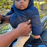 Rayan participe au concours pour gagner de l'argent avec cette photo : baby, child, puffer_jacket, beanie, outdoor, hands, car, reflection, sunlight, trees, greenery, curious, face, portrait, winter_clothing, jacket, pants, sock, person, daylight