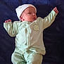 baby, infant, child, pajamas, hat, blanket, sleepwear, lying_down, newborn, cute, person, soft_fabric, comfortable, indoors, resting, small_hands, footed_pajamas, peaceful, warm_clothing, portrait