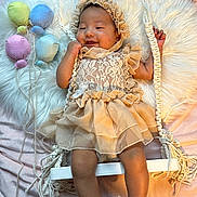 Mylanie joined the competition — help win amazing prizes! baby, infant, dress, lace, bonnet, swing, plush_balloons, fluffy_rug, pastel_colors, smiling, cute, child, indoor, decor, rope, footwear, pearl_bracelets, soft_lighting, happy, portrait