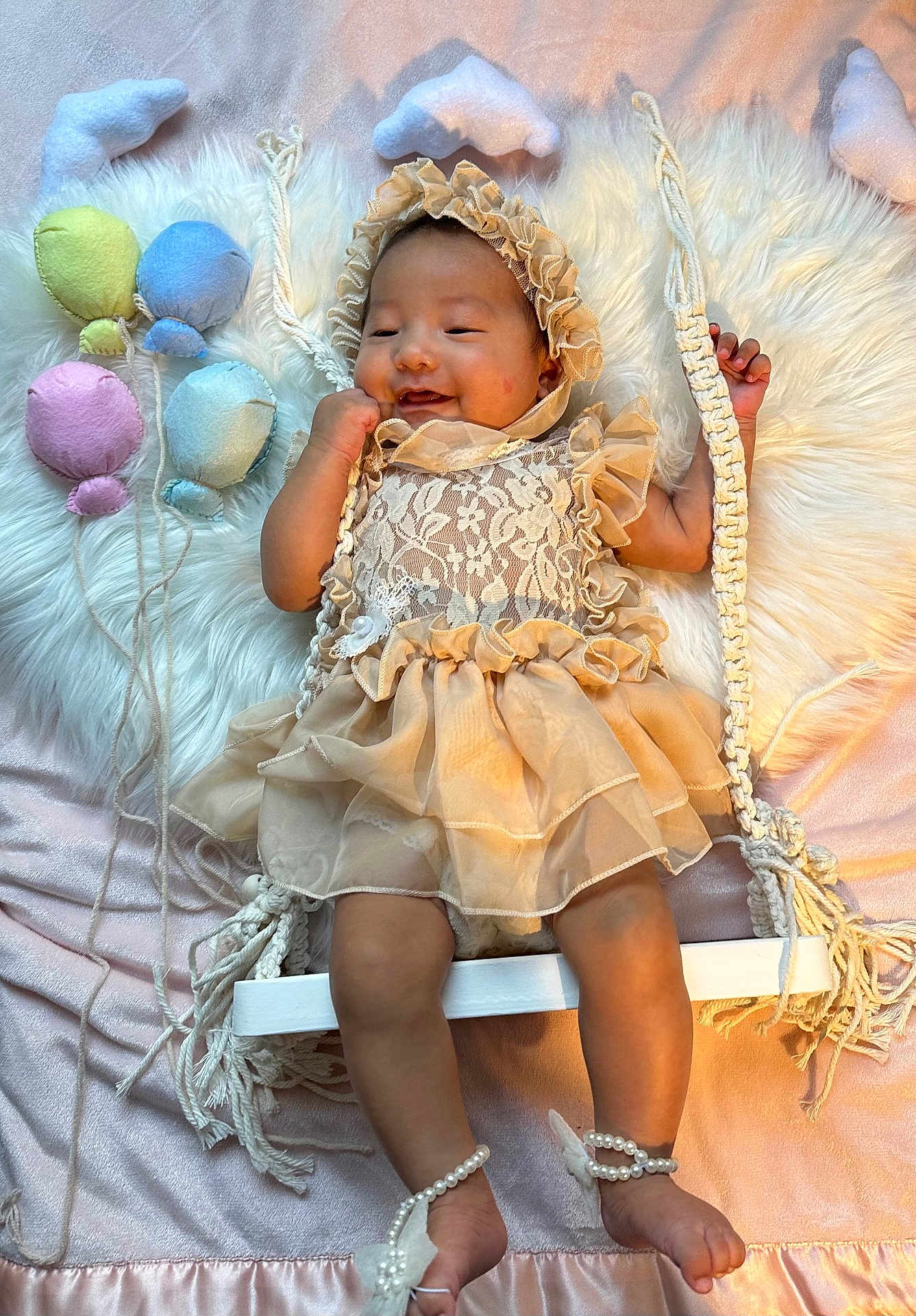 Mylanie joined the competition — help win amazing prizes! baby, infant, dress, lace, bonnet, swing, plush_balloons, fluffy_rug, pastel_colors, smiling, cute, child, indoor, decor, rope, footwear, pearl_bracelets, soft_lighting, happy, portrait