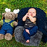 Dale is registered to the contest to win money with this photo: baby, infant, plush_toy, moose, stuffed_animal, grass, outdoor, blanket, cushion, sleeping, clothing, denim, green_shirt, blue_pants, cute, peaceful, nature, soft_texture, child, portrait