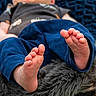 Dale is registered to the contest to win money with this photo: baby, feet, blue_pants, blanket, cozy, soft_texture, infant, toes, close_up, blurred_background, child, relaxing, casual_clothing, outdoor, grass, warm, comfort, resting, skin, small