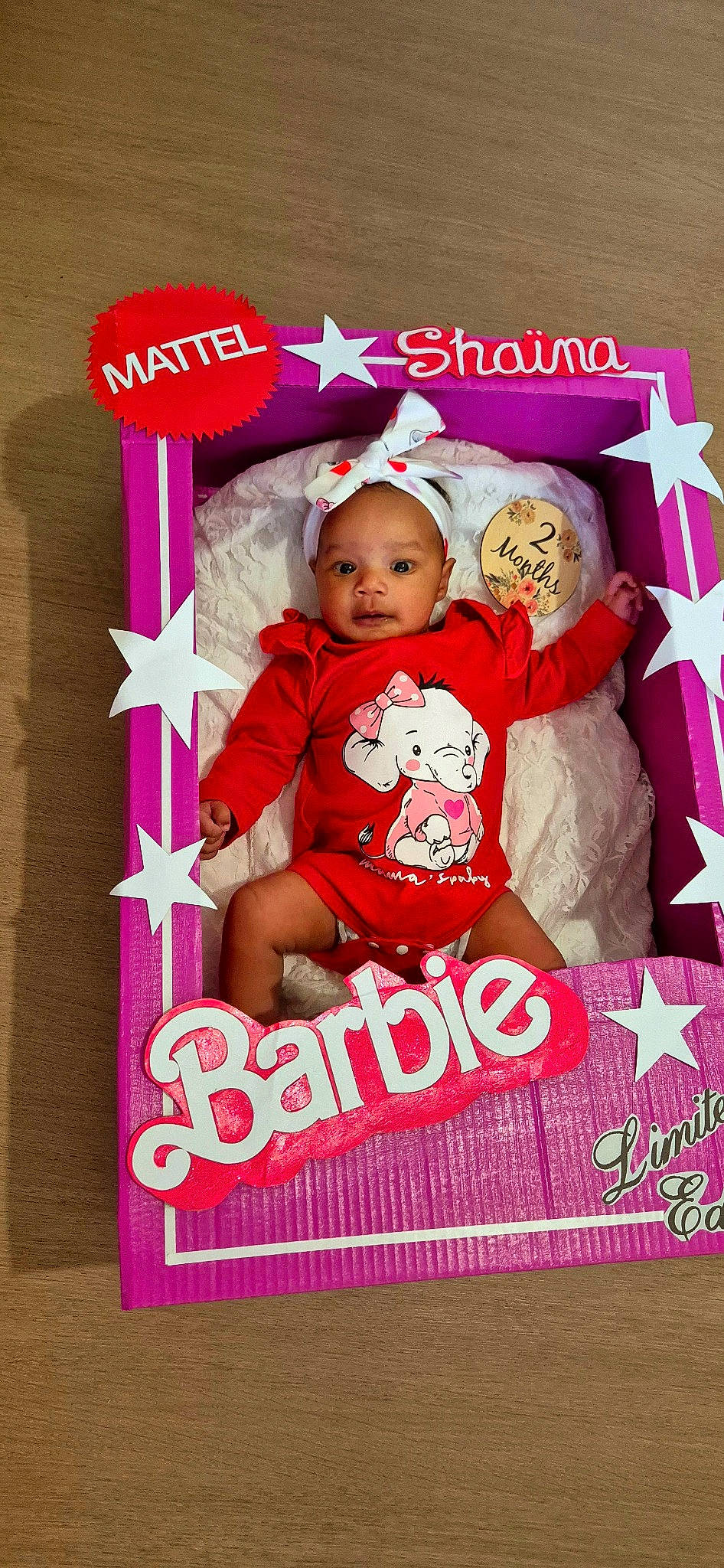 Shaïna participe au concours pour gagner de l'argent avec cette photo : advertising, baby, baby_products, baby_toddler_clothing, child, fictional_character, font, happy, logo, magenta, person, photo_caption, pink, publication, rectangle, room, sleeve, t_shirt, teddy_bear, textile