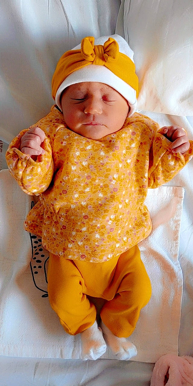 Aleyna participe au concours pour gagner de l'argent avec cette photo : arm, baby, baby_toddler_clothing, cap, child, face, facial_expression, goggles, head, headgear, headwear, human_body, orange, outerwear, pattern, peach, person, sleeve, textile, toddler