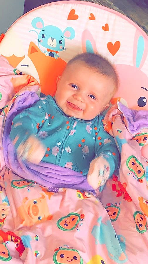 Hazellee is registered to the contest to win money with this photo: baby, baby_toddler_clothing, cheek, child, eye, face, facial_expression, happy, iris, joy, linens, orange, pattern, person, pink, product, skin, sleeve, smile, textile