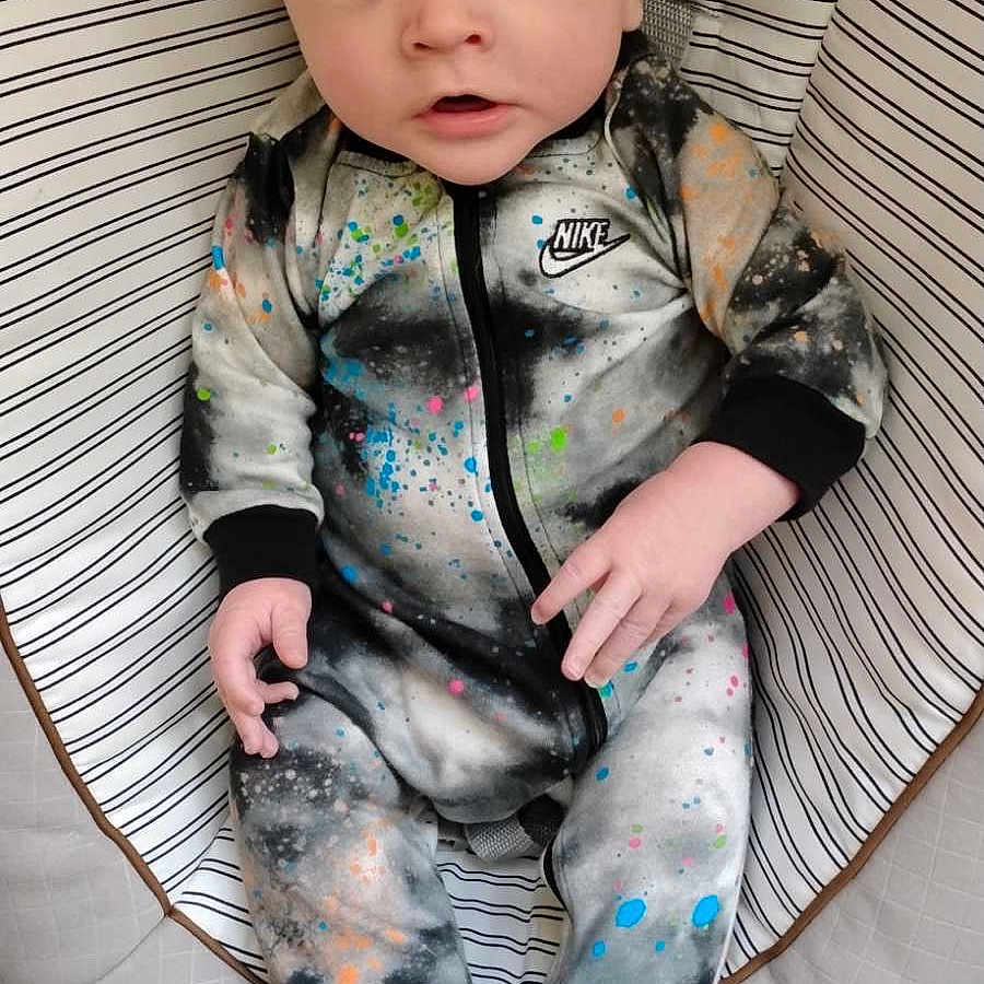 Elijah is registered to the contest to win money with this photo: baby, clothing, coat, cushion, face, formalwear, furniture, head, hosiery, jacket, longsleeve, pajamas, pants, person, photography, portrait, sitting, sleeve, sock, suit