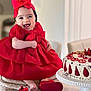 baby, child, red_dress, headband, bow, smiling, cake, strawberry, dessert, table, shoes, indoor, cute, happy, celebration, person, portrait, food, sitting, festive