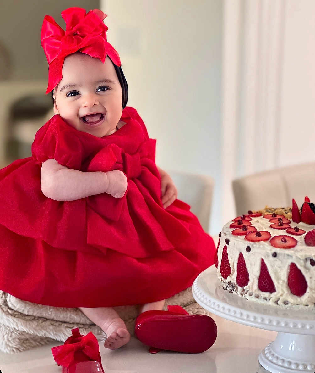 Gianna joined the competition — help win amazing prizes! baby, child, red_dress, headband, bow, smiling, cake, strawberry, dessert, table, shoes, indoor, cute, happy, celebration, person, portrait, food, sitting, festive