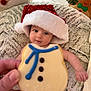 Amelia joined the competition — help win amazing prizes! baby, infant, santa_hat, cookie, hand, blanket, holiday, christmas, decorations, plush, face, blue_eyes, festive, cute, soft_texture, winter, cozy, closeup, smile, child