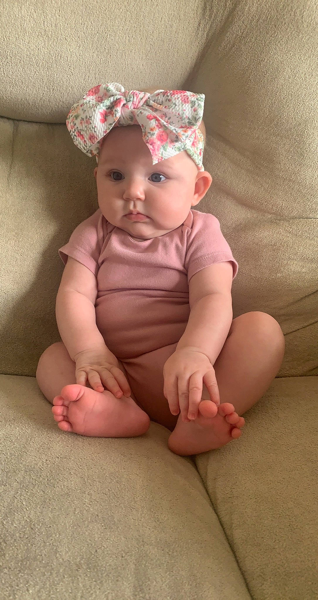 Amara is registered to the contest to win money with this photo: baby, baby_toddler_clothing, cheek, child, comfort, eye, fashion_accessory, finger, flooring, foot, head, headband, headgear, headwear, human_body, human_leg, person, pink, sitting, skin