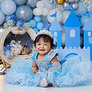 Julia Adrianna joined the competition — help win amazing prizes! baby, child, dress, blue_dress, tiara, birthday, one_year_old, smile, balloons, castle, decorations, fairy_lights, celebration, happy, portrait, floor, festive, cute, young_child, indoor