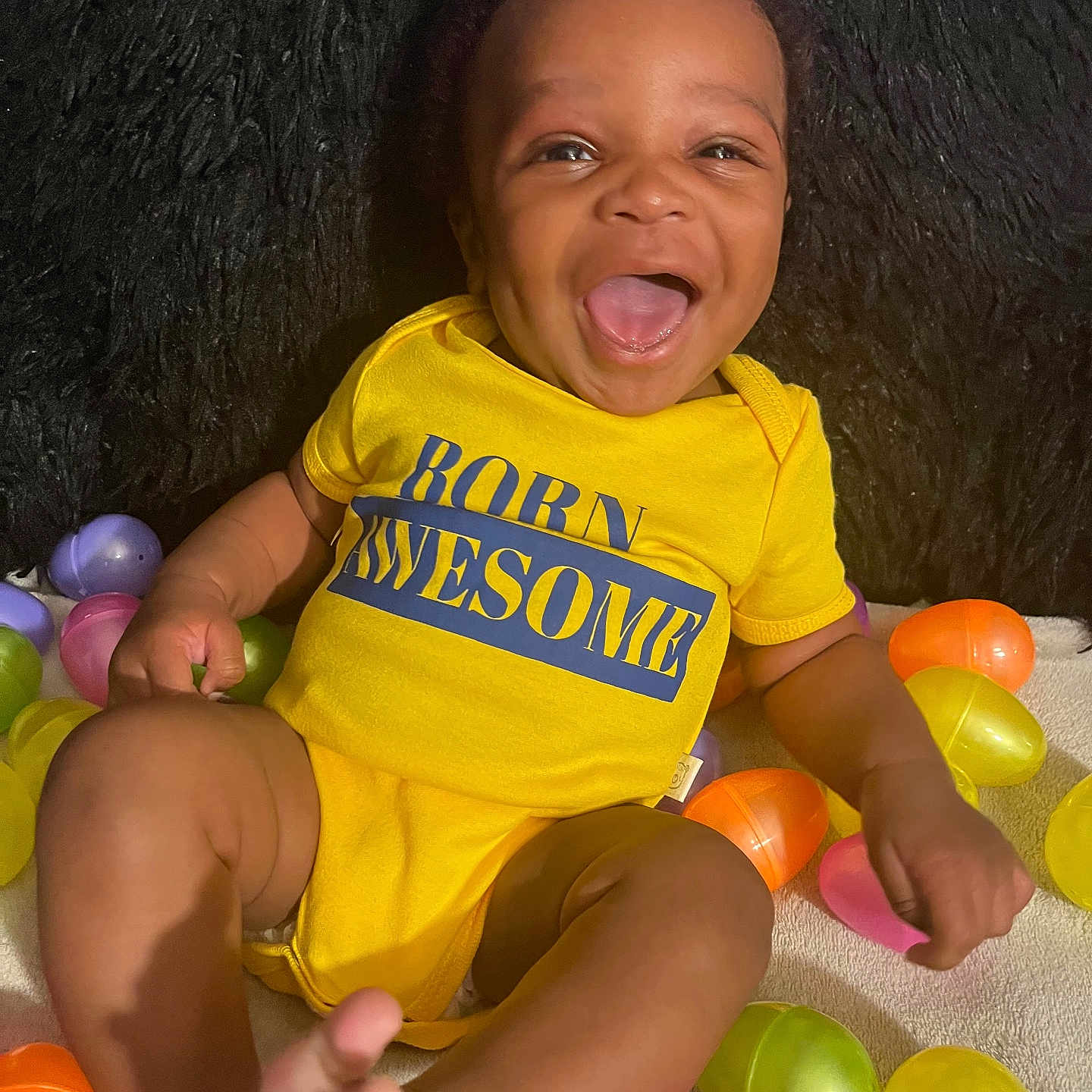 Gino is registered to the contest to win money with this photo: baby, babylaughing, balloon, bodypart, clothing, face, happy, head, laughing, mouth, person, photography, portrait, purple, shorts, sitting, smile, sphere, t_shirt, teeth