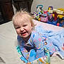 toddler, child, pajamas, bed, toy, soft_toy, blanket, smile, happy, indoor, furniture, carrot_toy, colorful, play, cute, person, face, hair, baby, room