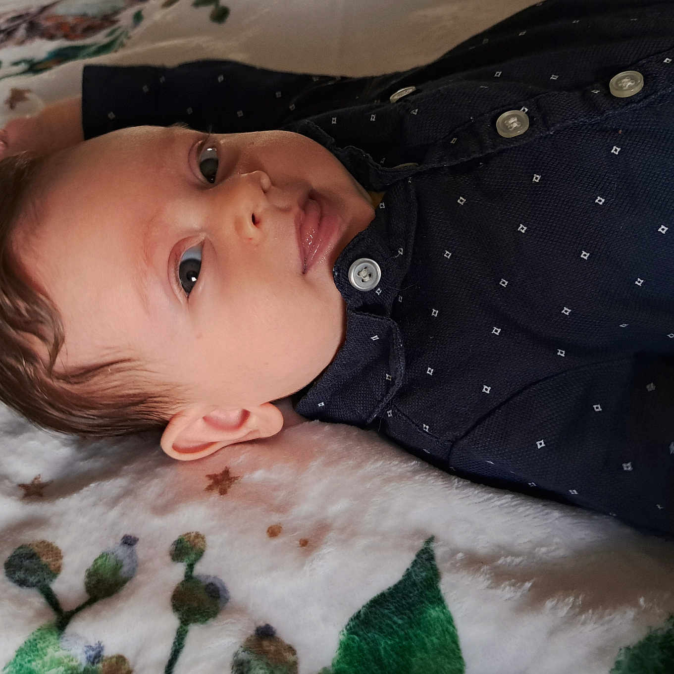 Aaron participe au concours pour gagner de l'argent avec cette photo : baby, blanket, child, closeup, clothing, cozy, curly_hair, ear, eyes, face, indoor, infant, lying_down, mouth, pattern, person, portrait, shirt, skin, soft_texture