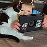 Sutton And Milo joined the competition — help win amazing prizes! child, cat, tablet, indoor, carpet, bed, curious, black_and_white_cat, playful, young_child, technology, hands, face, cozy, relaxed, digital_device, cute, pet, whiskers, drawing