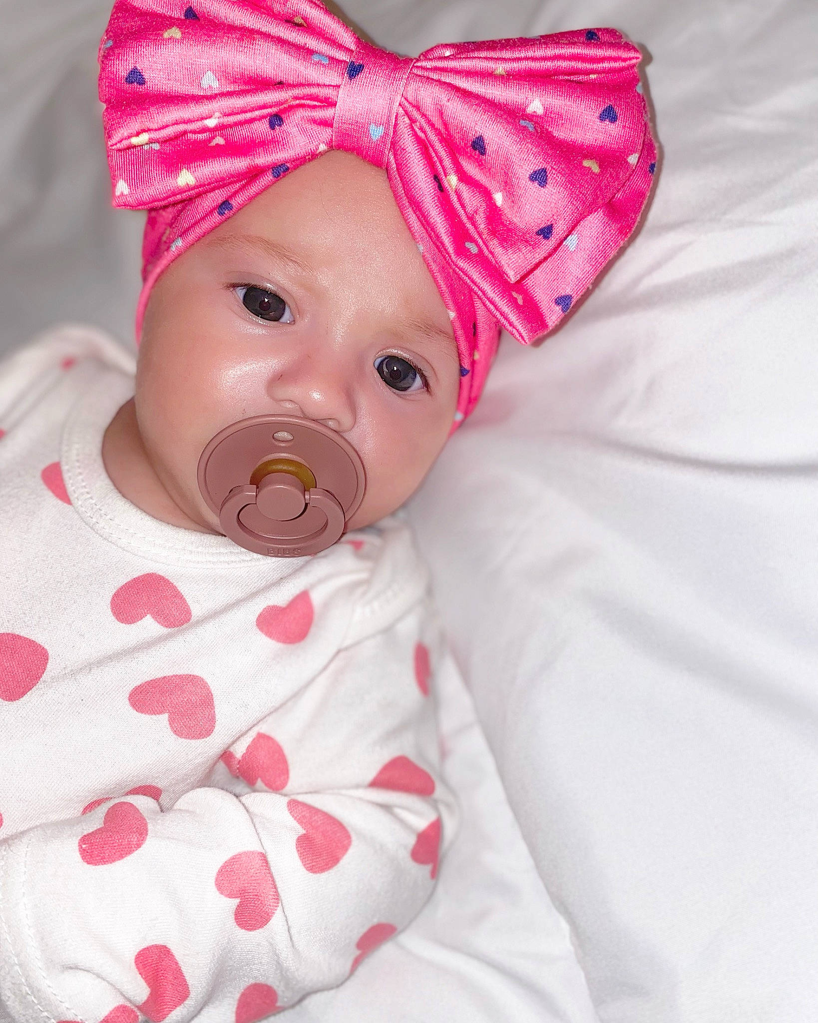 Delissya a rejoint le concours — aidez-le/la à gagner de superbes lots ! baby, baby_products, baby_toddler_clothing, beanie, cap, comfort, costume_hat, face, fashion_accessory, hair_accessory, hat, head, headwear, linens, magenta, party_hat, pattern, peach, person, pink