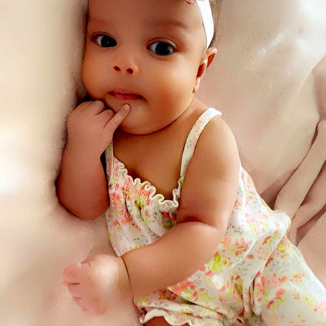 Jazariyah joined the competition — help win amazing prizes! baby, blanket, child, clothing, cute, eyes, face, floral_pattern, flower, hand, headband, indoor, infant, lying_down, newborn, pink, portrait, resting, skin, soft