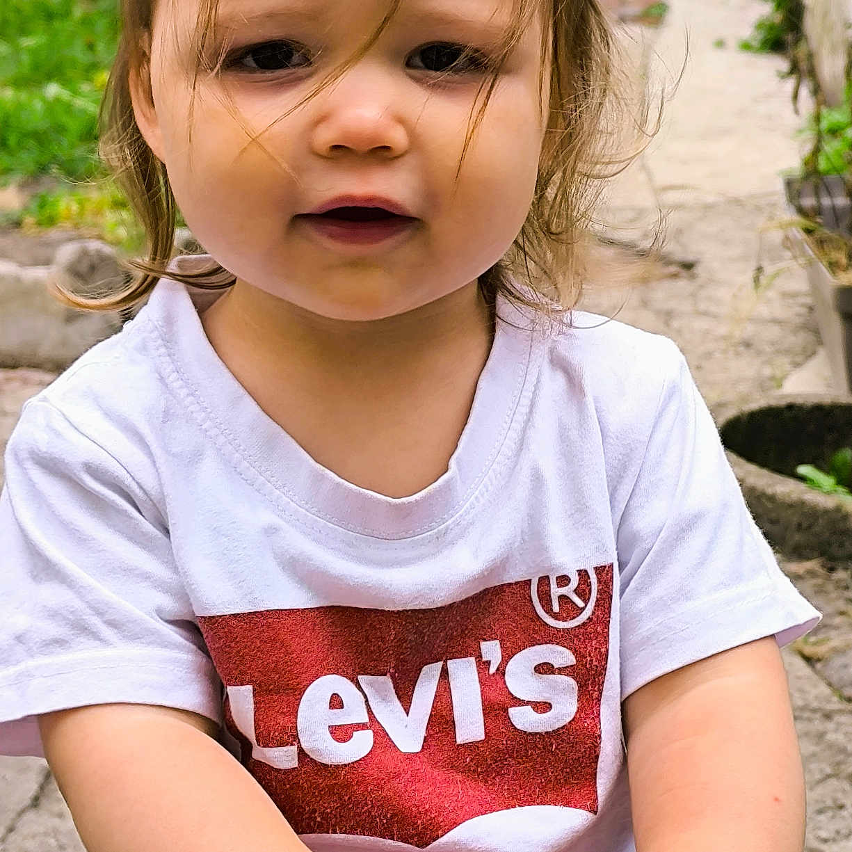 Lola participe au concours pour gagner de l'argent avec cette photo : casual_clothing, child, curly_hair, daylight, face, garden, grass, hair, hands, nature, outdoor, person, playground, red_shorts, smiling, toddler, toy, tshirt, white_clothing, young_child