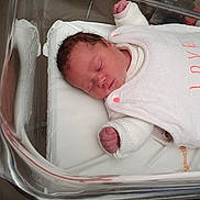 Lola participe au concours pour gagner de l'argent avec cette photo : newborn, baby, sleeping, hospital, bassinet, crib, infant, white_clothing, love_text, peaceful, portrait, person, indoors, blanket, cute, skin, head, hand, soft, resting