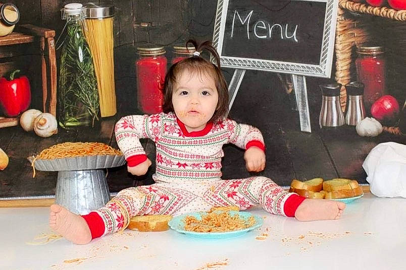 Anastacia is registered to the contest to win money with this photo: baby_toddler_clothing, bowl, chair, child, comfort_food, cuisine, dish, dishware, event, food, holiday, meal, person, picture_frame, plate, room, sharing, sweetness, table, tableware