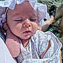 Olive is registered to the contest to win money with this photo: baby, sleeping, bonnet, white_clothing, floral_pattern, beach, sand, blanket, hand, person, sunlight, closeup, peaceful, infant, outdoor, skin, headwear, relaxation, soft_texture, summer