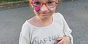 Oceane a rejoint le concours — aidez-le/la à gagner de superbes lots ! child, face_paint, glasses, outdoor, greenery, hedge, pavement, white_shirt, denim_shorts, sneakers, playful_expression, young, casual_clothing, person, summer, daylight, portrait, cute, standing, nature