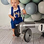 Ryder joined the competition — help win amazing prizes! toddler, child, toy_car, balloons, blue_clothing, barefoot, indoor, floor, suspenders, shorts, portrait, cute, playful, decor, birthday_theme, reflection, smiling, person, young_child, baby