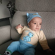 Raphaël a rejoint le concours — aidez-le/la à gagner de superbes lots ! armchair, baby, bear_design, beige_clothing, blue_clothing, cartoon_character, casual, child, cozy, cute, hat, home, indoor, infant, looking_away, person, portrait, seated, socks, soft_texture