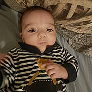 Raphaël participe au concours pour gagner de l'argent avec cette photo : baby, child, infant, striped_clothing, bear_graphic, bed, pillow, blanket, hand, face, indoor, person, cute, young_child, sleepwear, lying_down, portrait, expression, cozy, homedecor