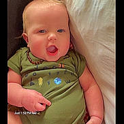 Jackson joined the competition — help win amazing prizes! arm, baby, child, couch, cute, green_onesie, hair, hand, head, indoors, infant, mouth_open, necklace, pillow, portrait, relaxed, seated, skin, smiling, young