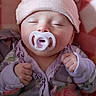 Nova joined the competition — help win amazing prizes! baby, infant, sleeping, pacifier, hat, bear_hat, floral_clothing, onesie, pink, purple, portrait, close_up, face, hands, indoors, blanket, soft_lighting, resting, peaceful, cute