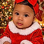 baby, celebration, child, christmas, christmas_tree, cute, face, festive, fur_trim, happy, holiday, holiday_decorations, indoors, infant, portrait, red_bow, red_dress, smile, soft_lighting, warm_colors