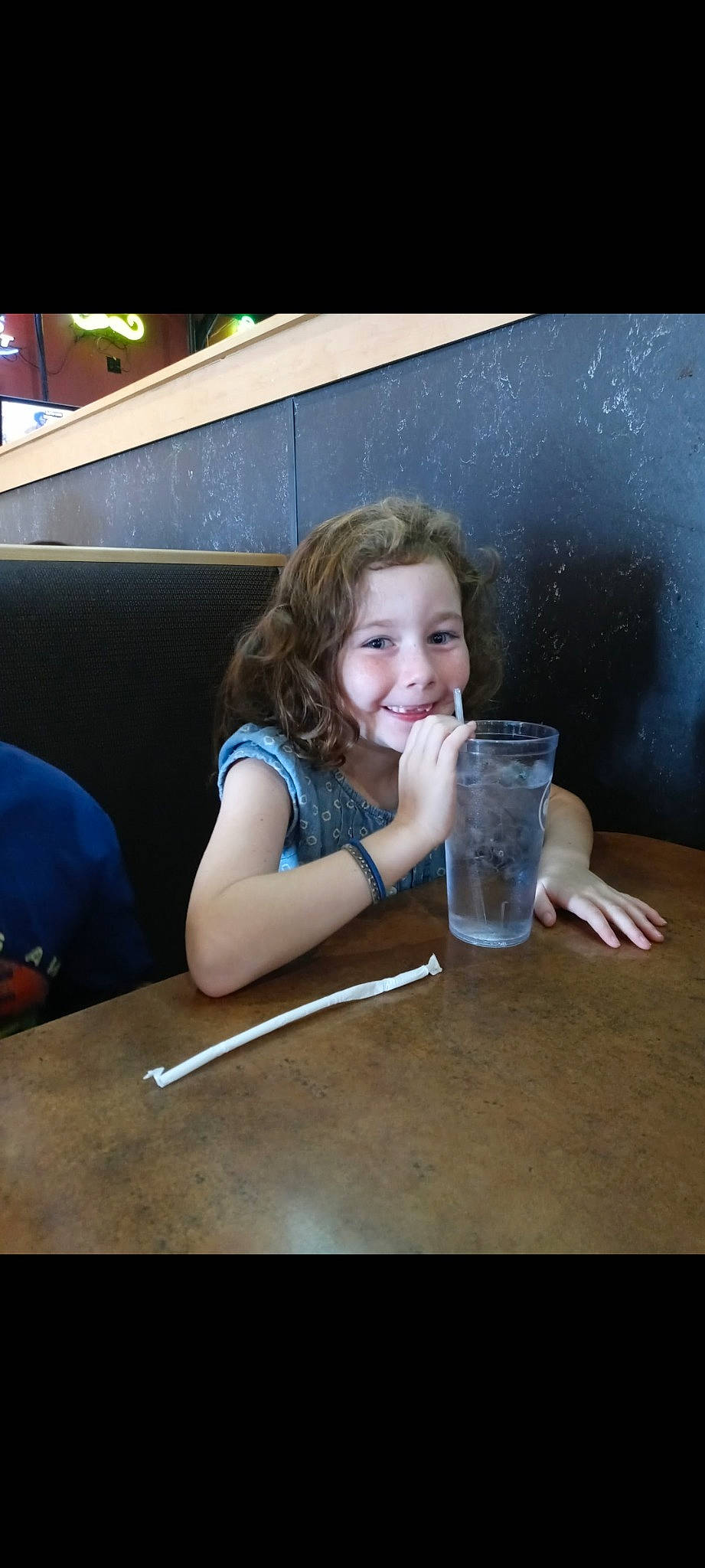 Sophia is registered to the contest to win money with this photo: blond, chair, child, drink, drinking, drinkware, flash_photography, flooring, fun, glass, happy, joy, leisure, person, sitting, smile, t_shirt, table, tableware, toddler