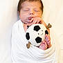 newborn, baby, sleeping, wrapped, blanket, plush_toy, soccer_ball, soft, cute, peaceful, infant, feet, hand, face, portrait, white_background, child, resting, cozy, adorable