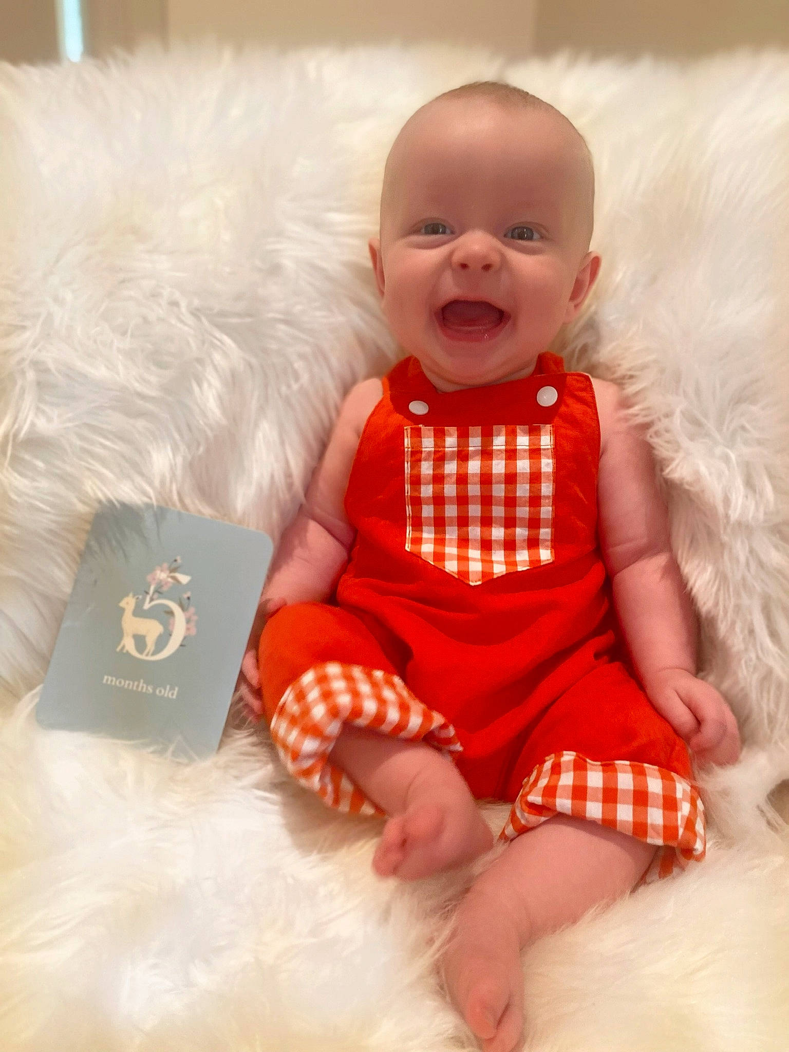 Flynn is registered to the contest to win money with this photo: baby, baby_toddler_clothing, child, comfort, day_dress, dress, finger, fun, happy, one_piece_garment, orange, pattern, peach, person, pink, product, sitting, skin, sleeve, smile