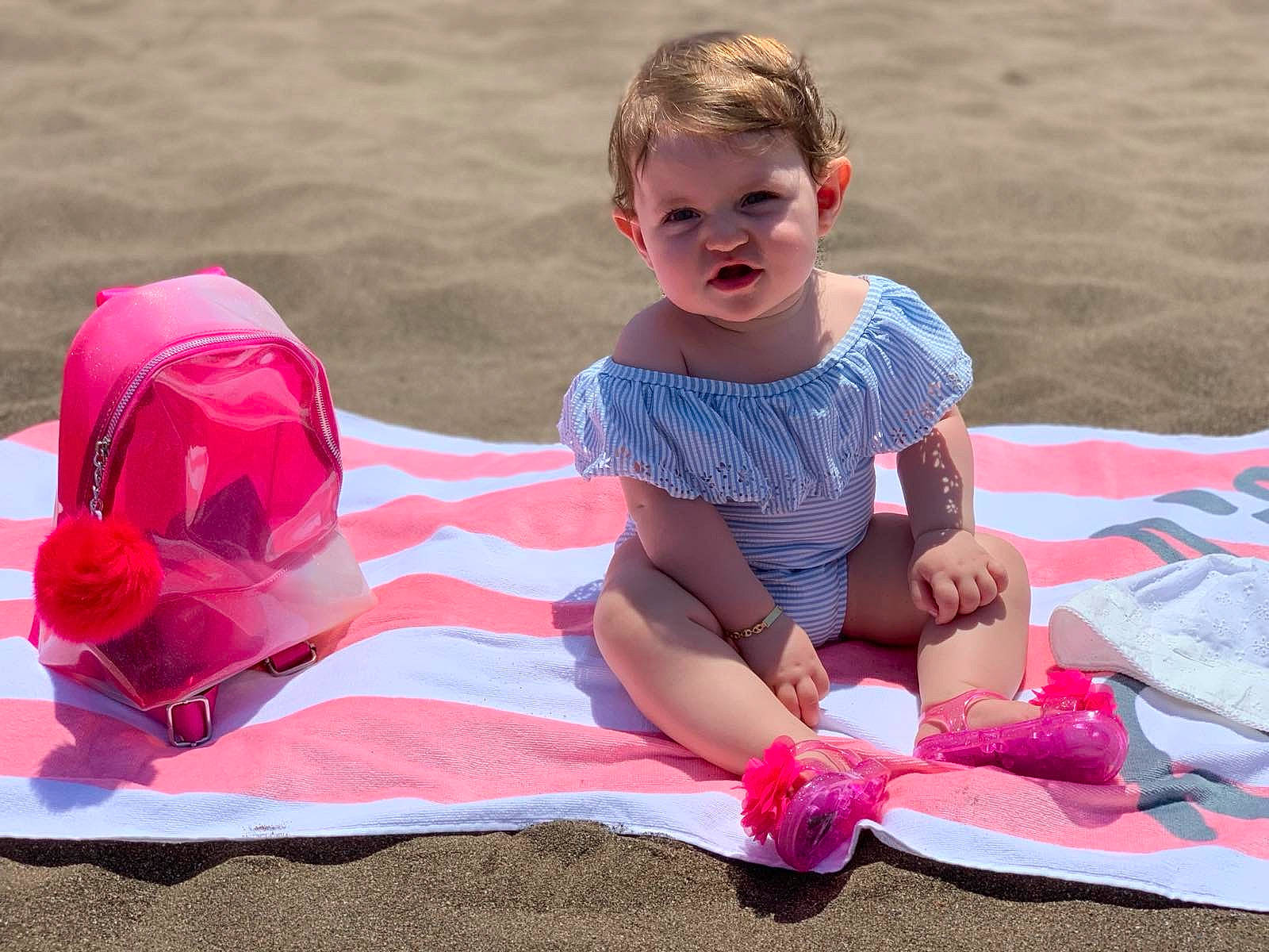 Ryna participe au concours pour gagner de l'argent avec cette photo : baby_toddler_clothing, barefoot, beach, body_of_water, carmine, child, event, fun, grass, happy, leisure, people_in_nature, people_on_beach, person, pink, recreation, sand, shorts, sitting, thigh