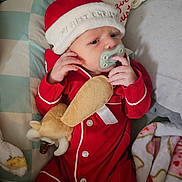 Carter is registered to the contest to win money with this photo: baby, blanket, child, christmas, comfort, cozy, cute, festive, holiday, indoors, infant, newborn, pacifier, pillow, plush_toy, red_pajamas, resting, santa_hat, sleepwear, soft