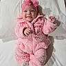 Elizabeth is registered to the contest to win money with this photo: baby, infant, child, smiling, portrait, pink_outfit, fluffy_clothing, headband, bow, white_bedding, bed, lying_down, indoors, face, hands, mittens, socks, cute, happy, soft_lighting