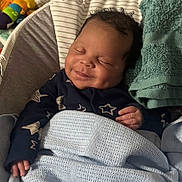 Issac joined the competition — help win amazing prizes! baby, smiling, sleeping, blanket, towel, clothing, hand, face, infant, cozy, resting, indoor, cute, peaceful, newborn, child, portrait, soft, comfort, toy