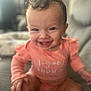 Evelyn is registered to the contest to win money with this photo: baby, smiling, curly_hair, child, indoor, couch, clothing, happy, person, infant, cute, portrait, sitting, young_child, face, expression, warm_light, cozy, blurred_background, casual