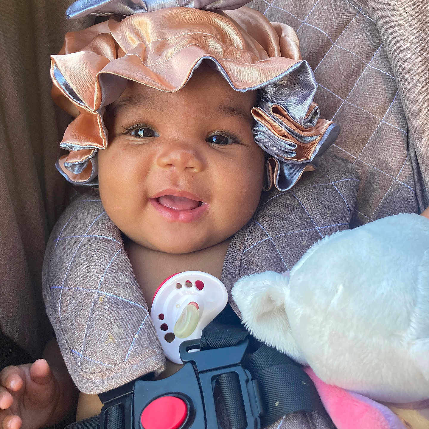 Nëylla a rejoint le concours — aidez-le/la à gagner de superbes lots ! baby, bonnet, car_seat, child, close_up, clothing, cute, face, happy, hat, headwear, indoors, infant, pacifier, plush_toy, portrait, safety_harness, seat_belt, smile, soft_toy